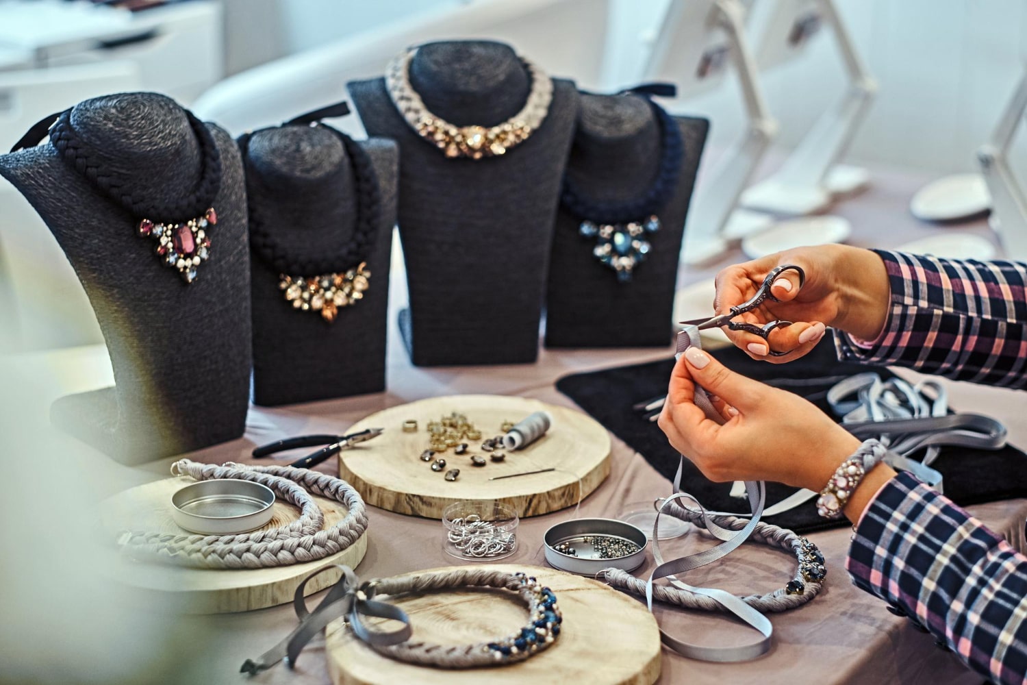 Crafting jewelry, necklaces displayed, tools in hand in Saudi Arabia.