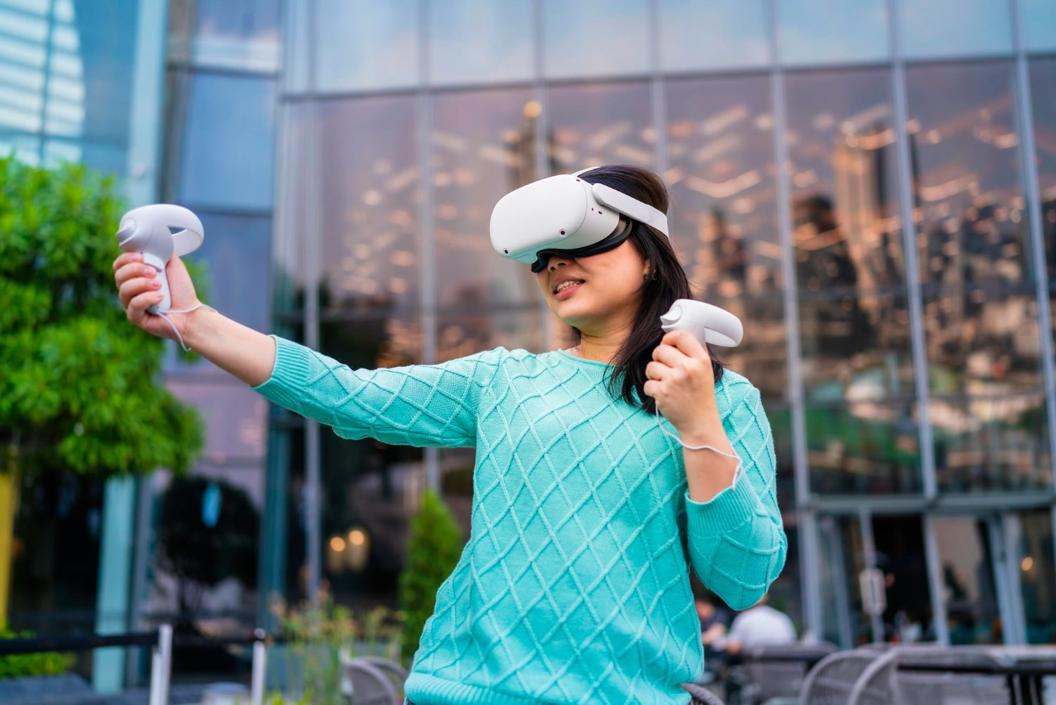 Woman using VR headset outdoors, modern birthday gift idea in Saudi Arabia