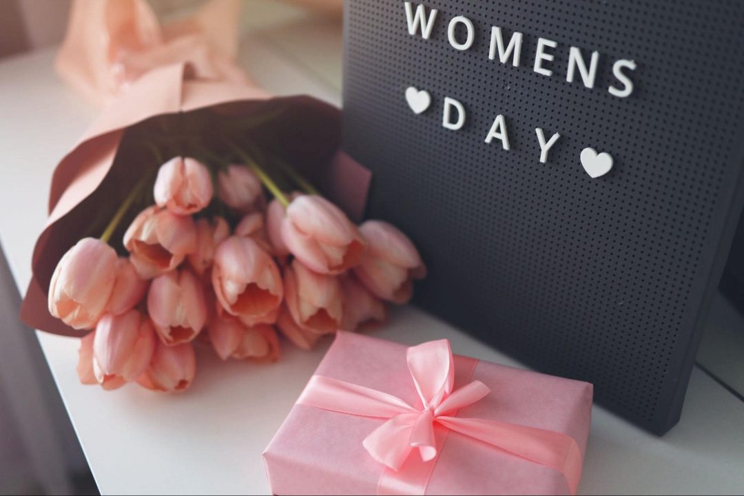 Women's Day sign with pink tulips and present